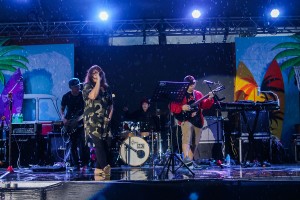 a photo of a band playing on stage while rain is pouring