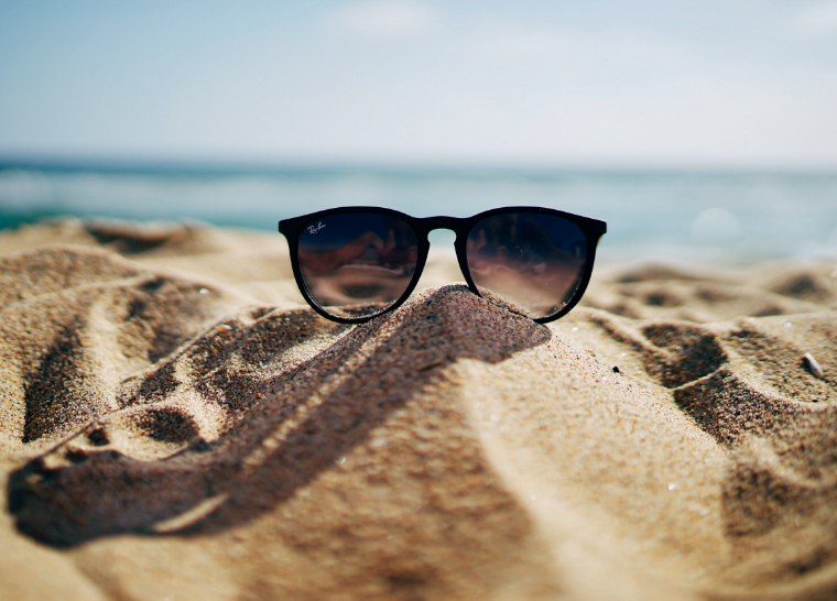 travel image sunglasses on the sand